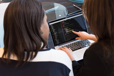 Persona desarrolladora escribiendo código en un portátil