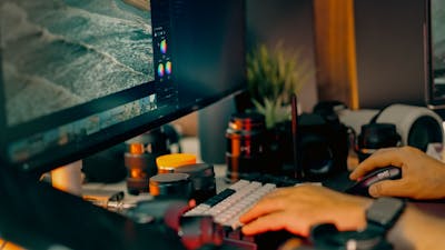 Espacio de trabajo de edición fotográfica con monitor y equipo profesional