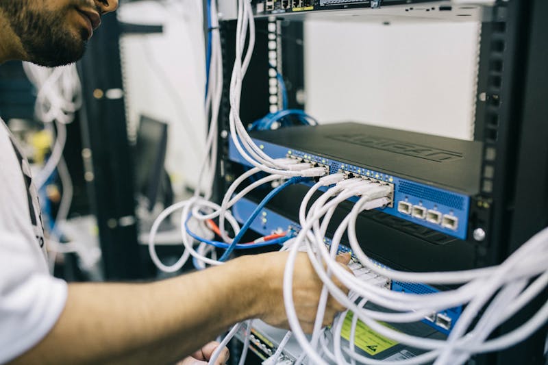 Ingeniero de redes configurando cables en un rack de servidores