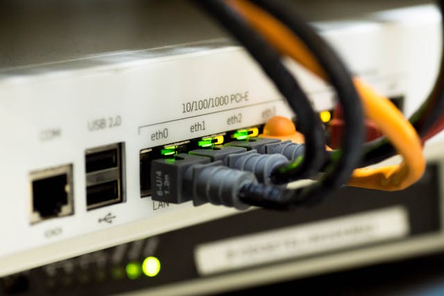 Switch de red con múltiples cables Ethernet conectados y luces LED indicadoras de actividad