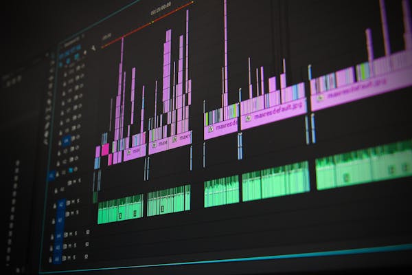 Persona trabajando en edición de vídeo con múltiples monitores